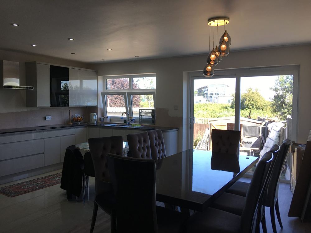 Kitchen and dining space opening to the garden through full-height glazing