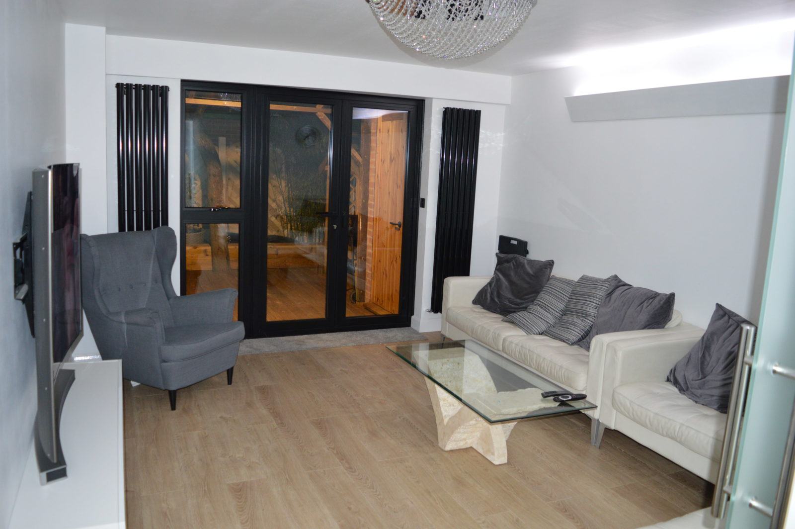 Bright living room with anthracite bifold doors opening onto a decked garden